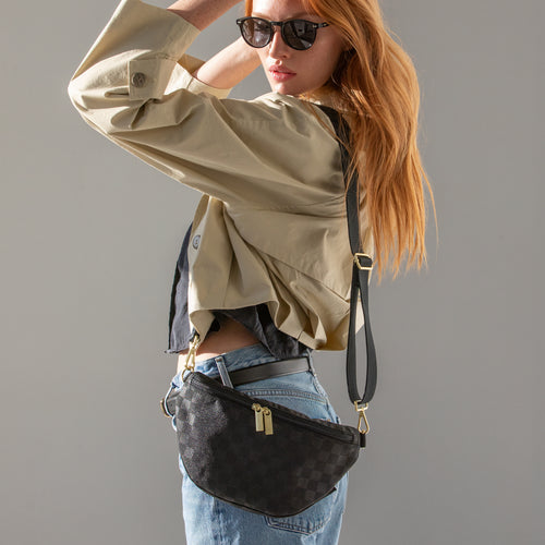 Black checkered Canvelle Bum Bag worn across the body with a cream jacket.