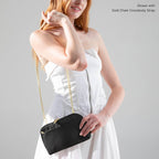 Woman wearing the Black Canvelle Crossbody Wallet on the Gold Chain Crossbody Strap with a white strapless dress