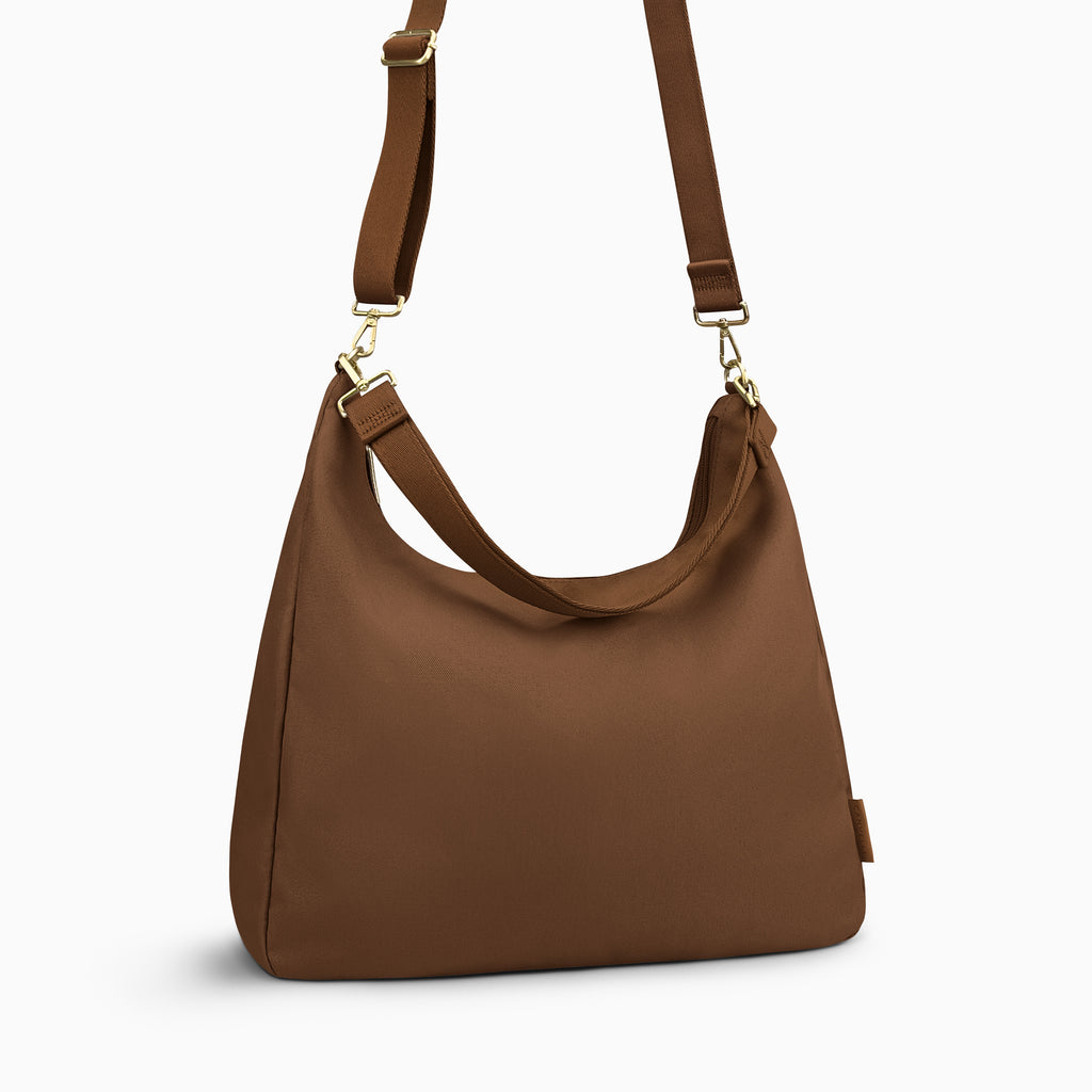 Canvelle Hobo Handbag in large brown canvas - Angled view with crossbody strap showing depth and side profile.
