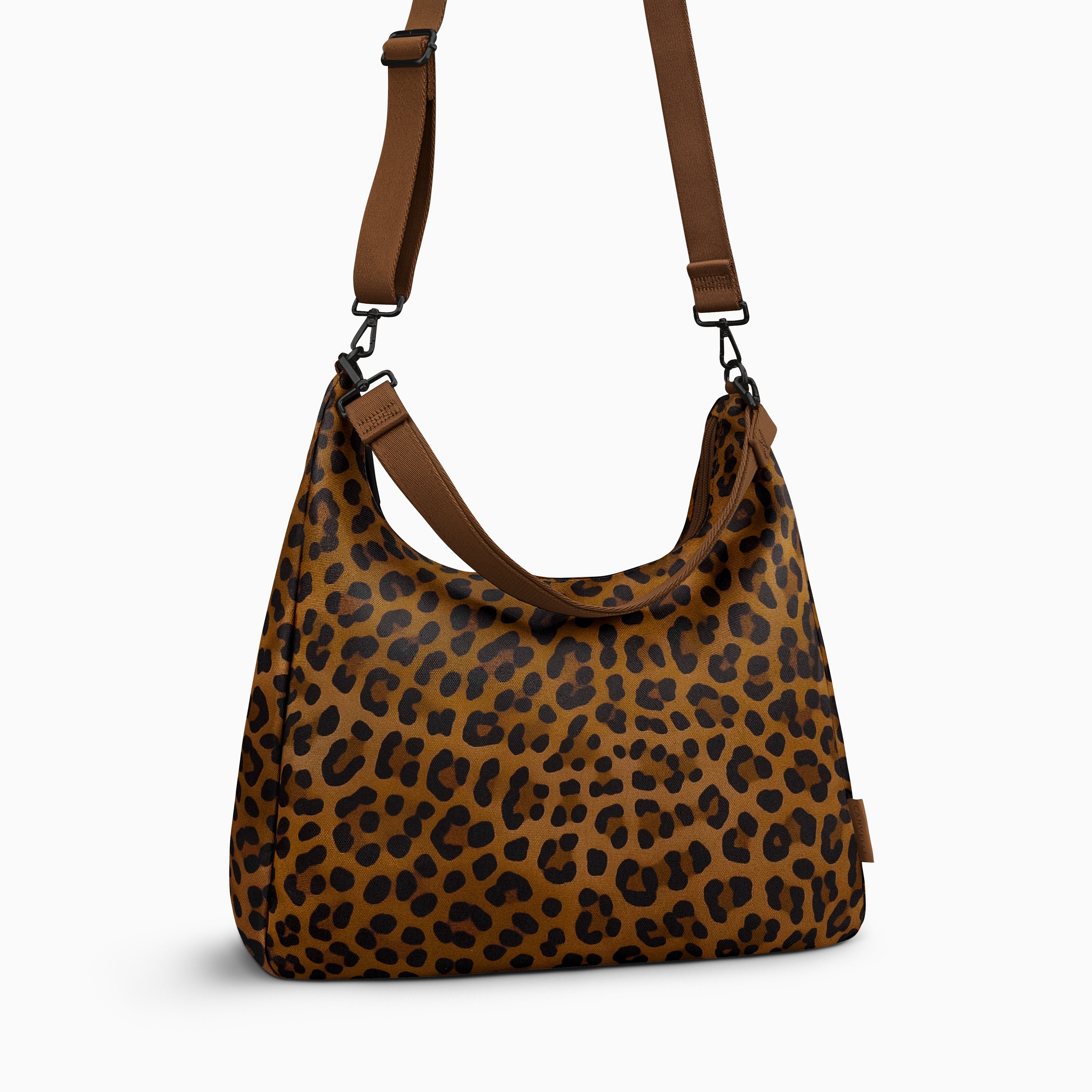Canvelle Hobo Handbag in large brown leopard print canvas - Angled view with crossbody strap showing depth and side profile.