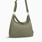 Canvelle Hobo Handbag in large olive canvas - Angled view with crossbody strap showing depth and side profile.