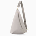 Oversized Canvelle Contour Sling Bag in grey recycled polyester canvas with gold hardware – front view.