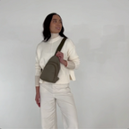 Video thumbnail showing a 360-degree view of the small quilted black Canvelle City Sling Bag worn across the chest to demonstrate fit, silhouette, and ergonomic profile from all angles.