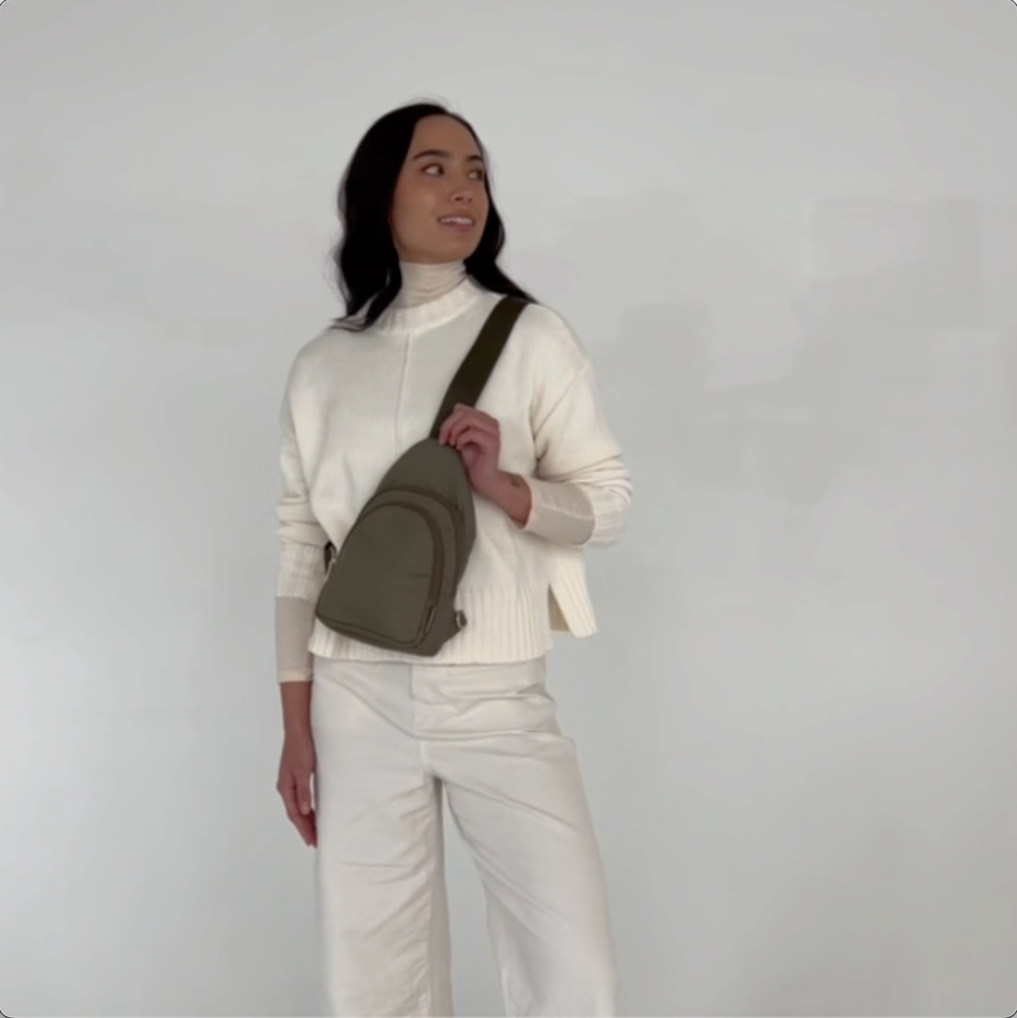 Video thumbnail showing a 360-degree view of the small olive green Canvelle City Sling Bag worn across the chest to demonstrate fit, silhouette, and ergonomic profile from all angles.